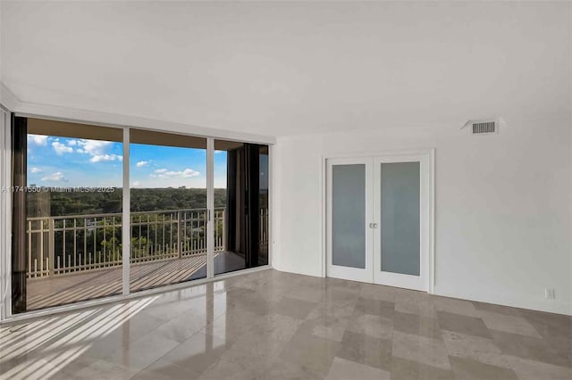 unfurnished room with french doors and floor to ceiling windows