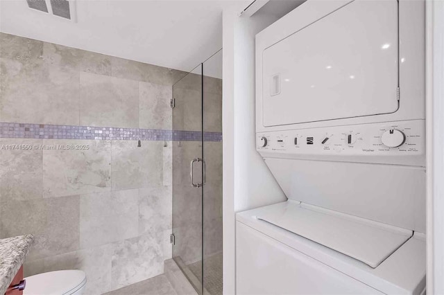 2000 Towerside Ter Unit 910, Miami, FL 33138 - full bath with stacked washing machine and dryer, a shower stall, and toilet