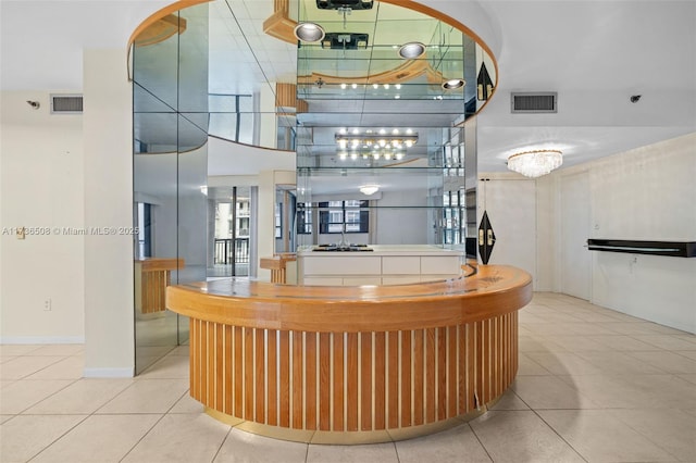 bar featuring a high ceiling and light tile patterned floors