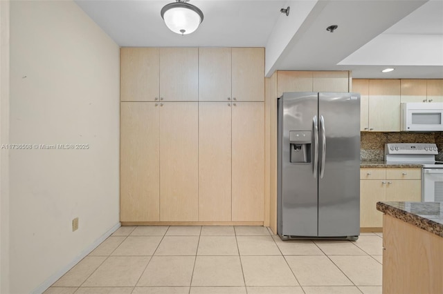 kitchen featuring backsplash, light tile patterned floors, light brown cabinetry, and white appliances