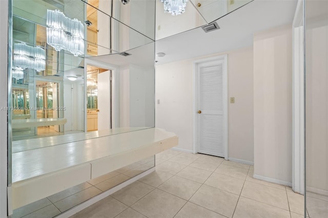 bathroom with a towering ceiling and tile patterned flooring