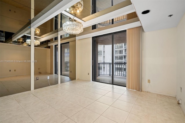 empty room featuring a notable chandelier and tile patterned floors