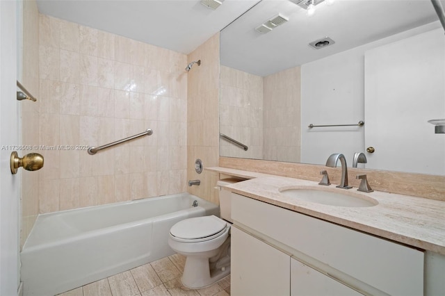 full bathroom featuring vanity, tiled shower / bath, and toilet