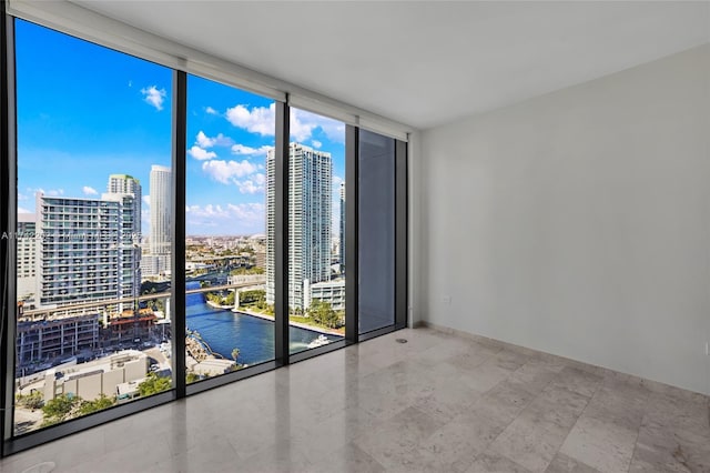 unfurnished room with a water view and a wall of windows