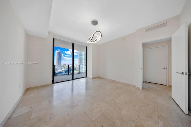 unfurnished room featuring a wall of windows