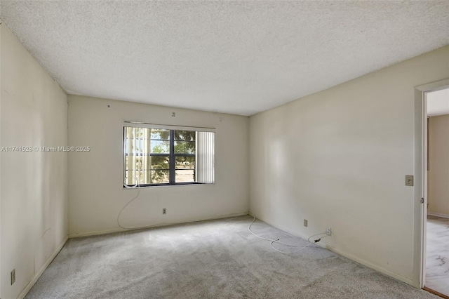 spare room with light carpet and a textured ceiling