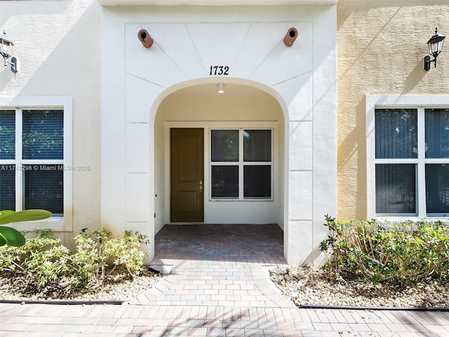 entrance to property featuring stucco siding