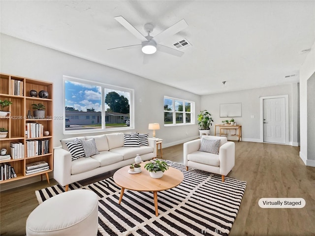 living room with wood-type flooring and ceiling fan