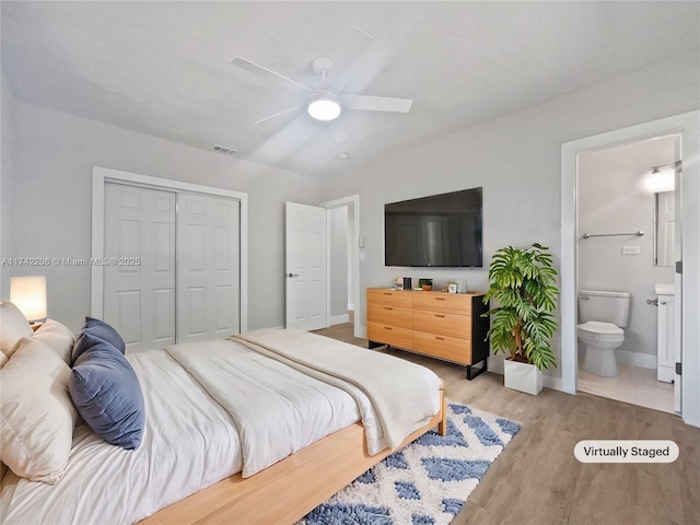 bedroom featuring ensuite bath, light hardwood / wood-style flooring, a closet, and ceiling fan