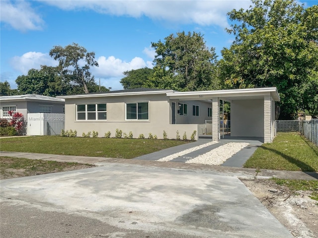 ranch-style home with a front yard and a carport