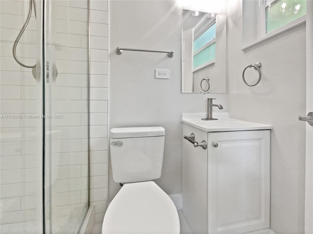 bathroom featuring vanity, an enclosed shower, and toilet