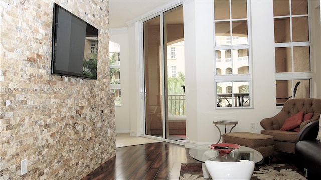 doorway featuring brick wall and hardwood / wood-style floors