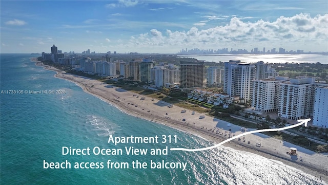 birds eye view of property featuring a beach view and a water view