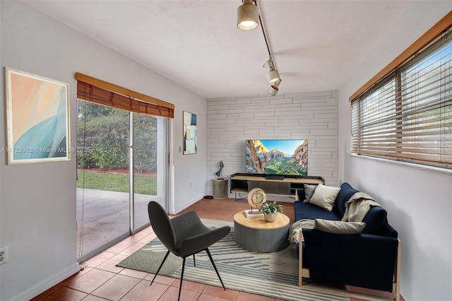 living room featuring rail lighting, a healthy amount of sunlight, and light tile patterned flooring