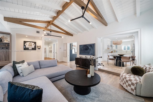 living room with wood ceiling, ceiling fan, lofted ceiling with beams, and light hardwood / wood-style flooring