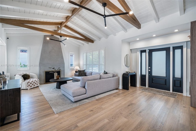 living area with wooden ceiling, light wood finished floors, high vaulted ceiling, and beamed ceiling