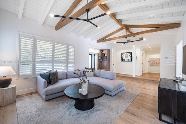 living area with vaulted ceiling with beams, light wood finished floors, a ceiling fan, wood ceiling, and baseboards