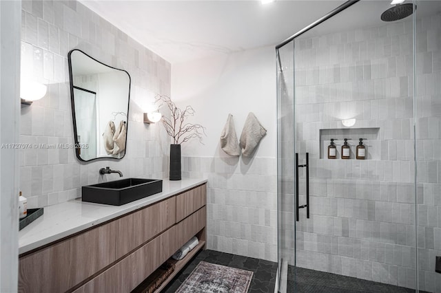 full bathroom with a shower stall, tile walls, and vanity