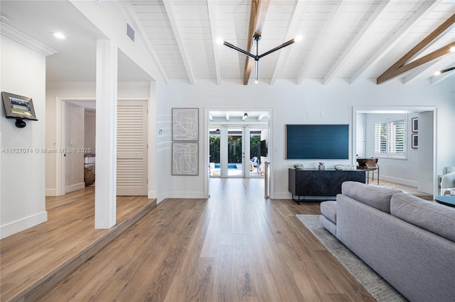 living room featuring a wealth of natural light, french doors, beam ceiling, and wood finished floors