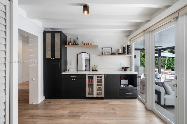 bar featuring wine cooler, beam ceiling, light wood finished floors, and a dry bar