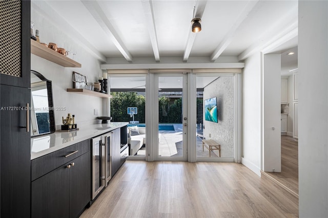 kitchen with wine cooler, dark cabinets, light countertops, open shelves, and beam ceiling