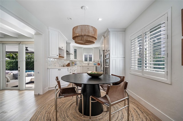 dining area featuring visible vents, light wood-style flooring, and baseboards