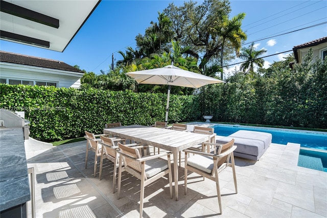 view of patio / terrace with a grill, outdoor dining area, and a fenced in pool