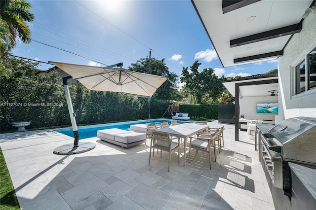 view of patio with an outdoor kitchen, a fenced in pool, a fenced backyard, outdoor dining area, and a playground