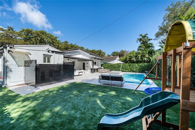 view of yard with a fenced in pool, a playground, a patio, and an outdoor structure