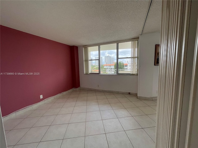 tiled empty room with a textured ceiling