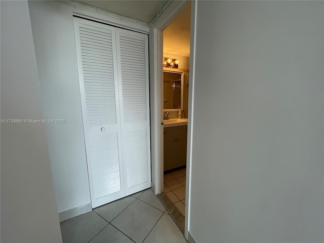 hall featuring sink and light tile patterned floors