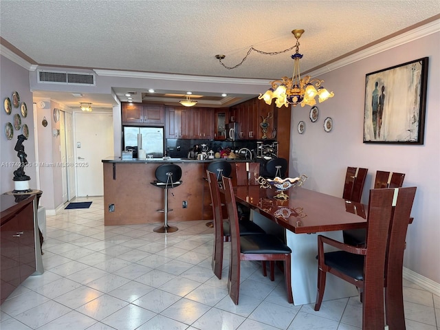 tiled dining area featuring crown molding, a chandelier, and a textured ceiling