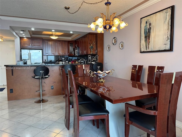 dining area featuring ornamental molding, light tile patterned floors, a textured ceiling, and a tray ceiling