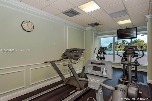 exercise room with crown molding and a paneled ceiling