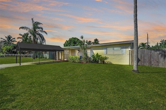 ranch-style home with a lawn and a carport