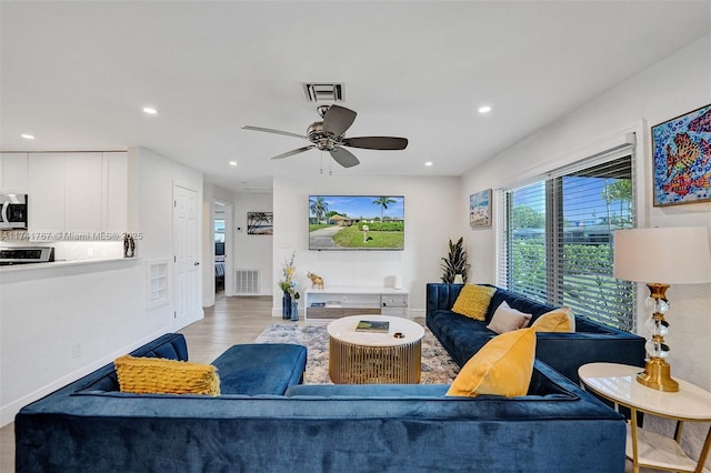 living room with ceiling fan and light hardwood / wood-style floors