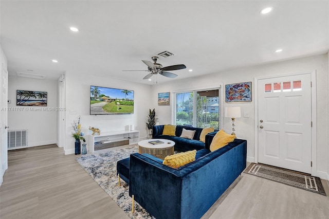 living room with ceiling fan and light hardwood / wood-style flooring