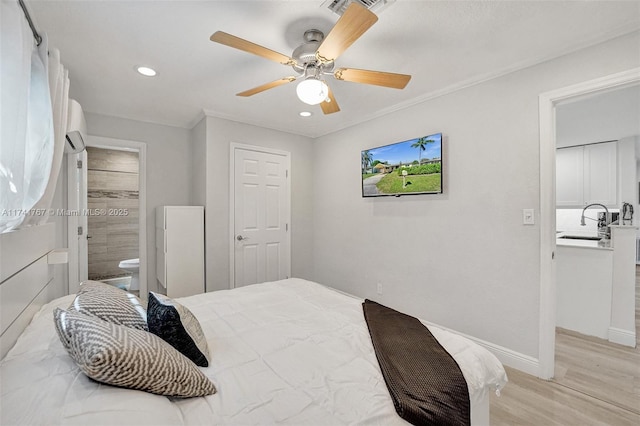 bedroom featuring sink, ensuite bath, light wood-type flooring, ornamental molding, and ceiling fan