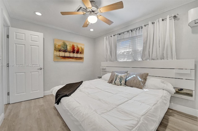 bedroom with ceiling fan, crown molding, light hardwood / wood-style flooring, and a wall mounted AC