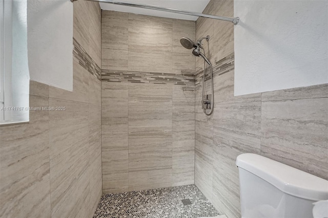 bathroom featuring tiled shower and toilet