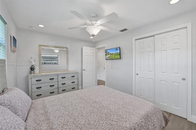 bedroom with light hardwood / wood-style flooring, a closet, and ceiling fan