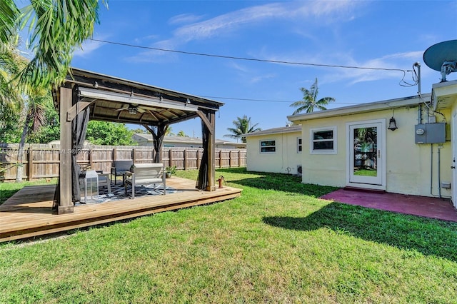 view of yard with a deck and ceiling fan