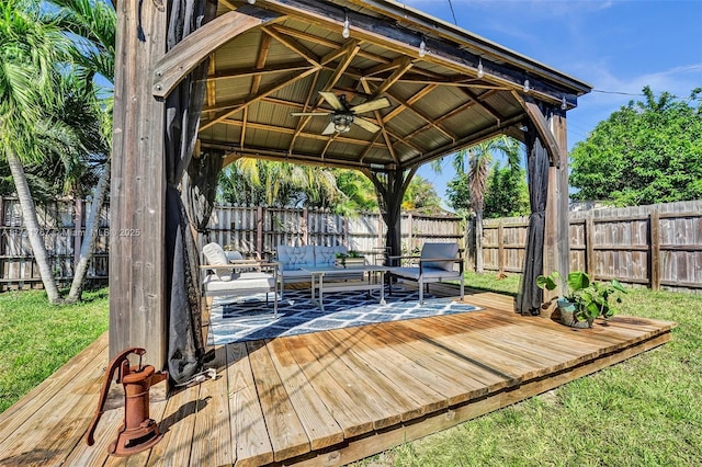 wooden deck with an outdoor living space, a gazebo, and ceiling fan