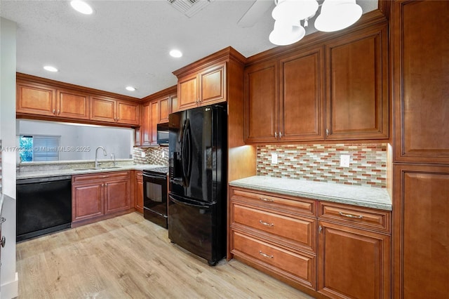 kitchen with sink, light stone counters, tasteful backsplash, light hardwood / wood-style floors, and black appliances