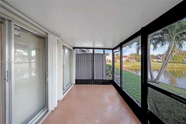 unfurnished sunroom with a water view