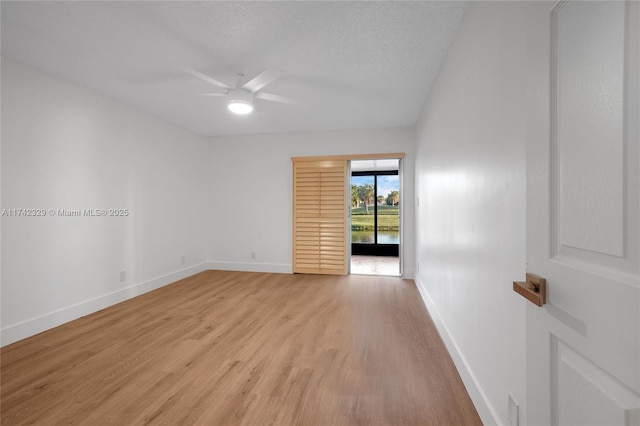 empty room featuring ceiling fan, light hardwood / wood-style floors, and a textured ceiling