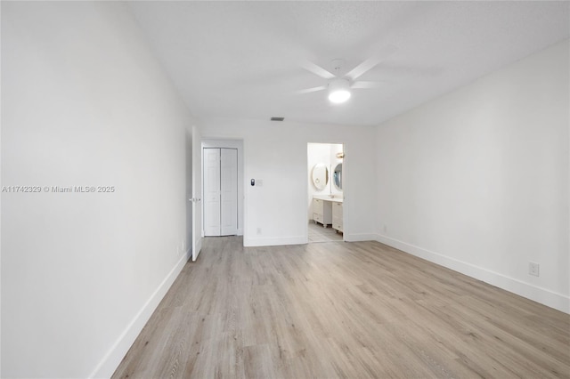 unfurnished bedroom featuring ceiling fan, ensuite bath, and light hardwood / wood-style floors