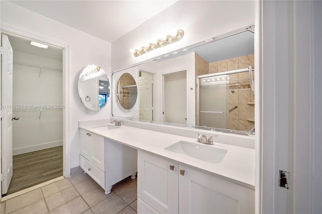 bathroom featuring vanity, a shower with door, and tile patterned flooring