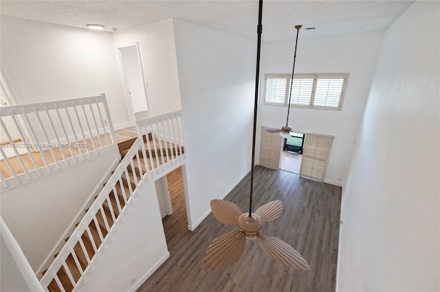 stairs featuring hardwood / wood-style flooring and a textured ceiling