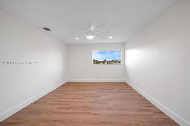 spare room featuring a textured ceiling, ceiling fan, and light hardwood / wood-style flooring